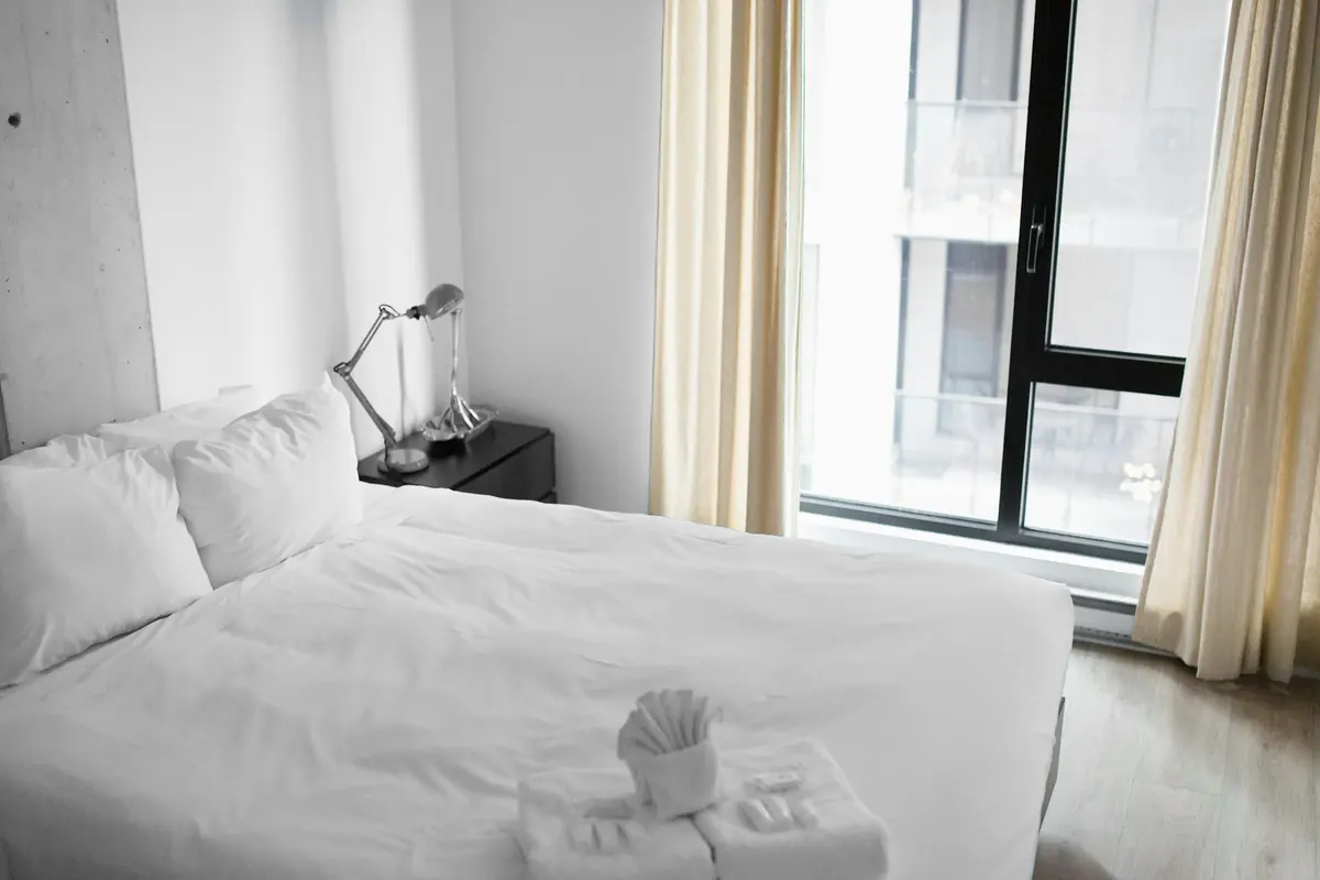 Chambre lumineuse avec lit fait et serviettes pliées prêtes pour les voyageurs