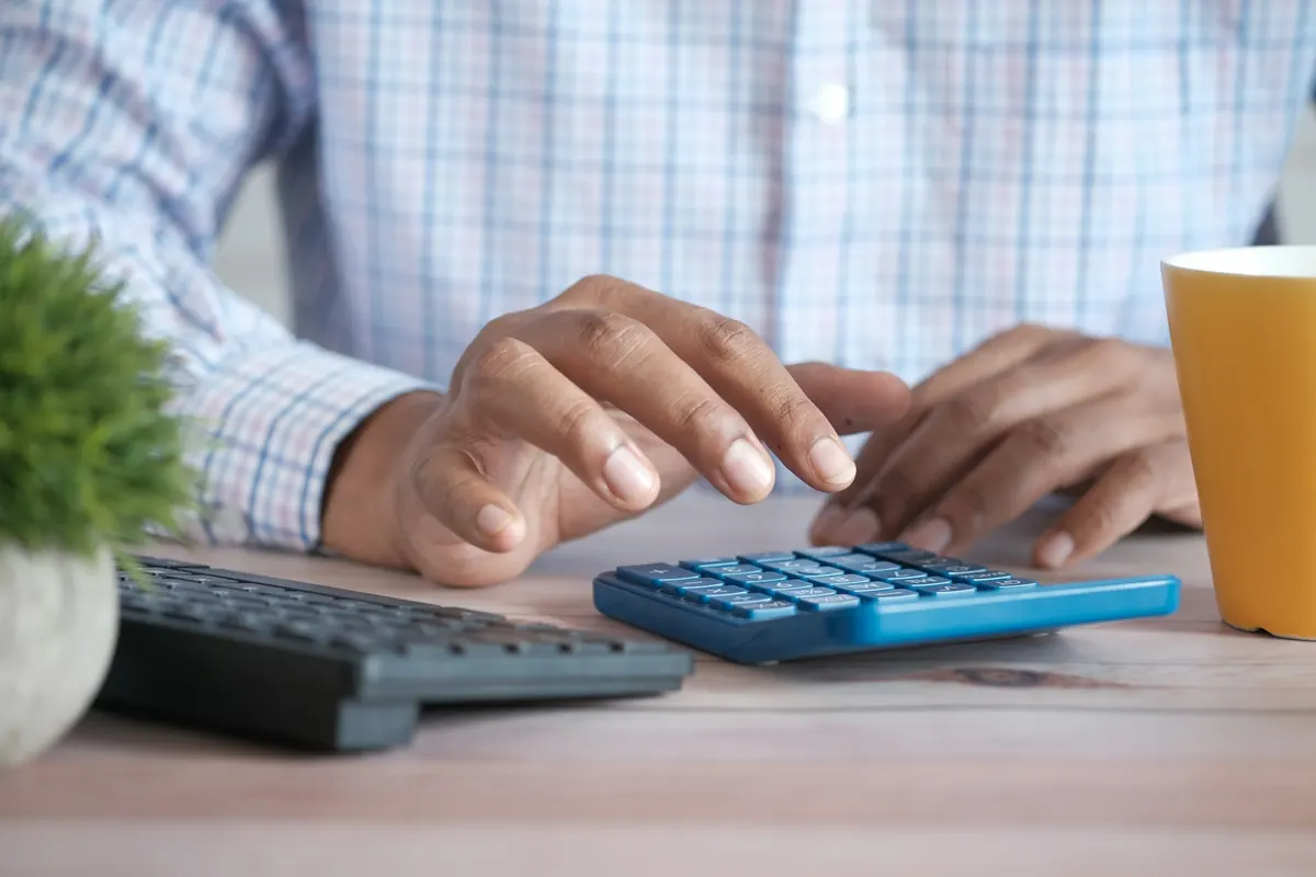 Calcul d’une commission sur une calculatrice posée sur un bureau