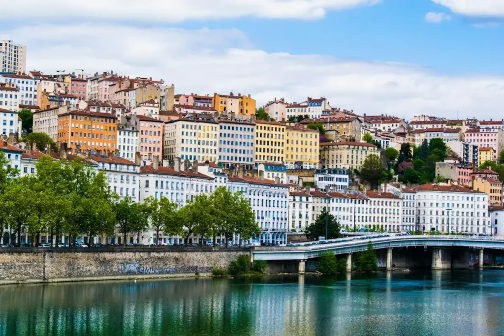 Façades colorées de Lyon au bord de l’eau sous un ciel bleu