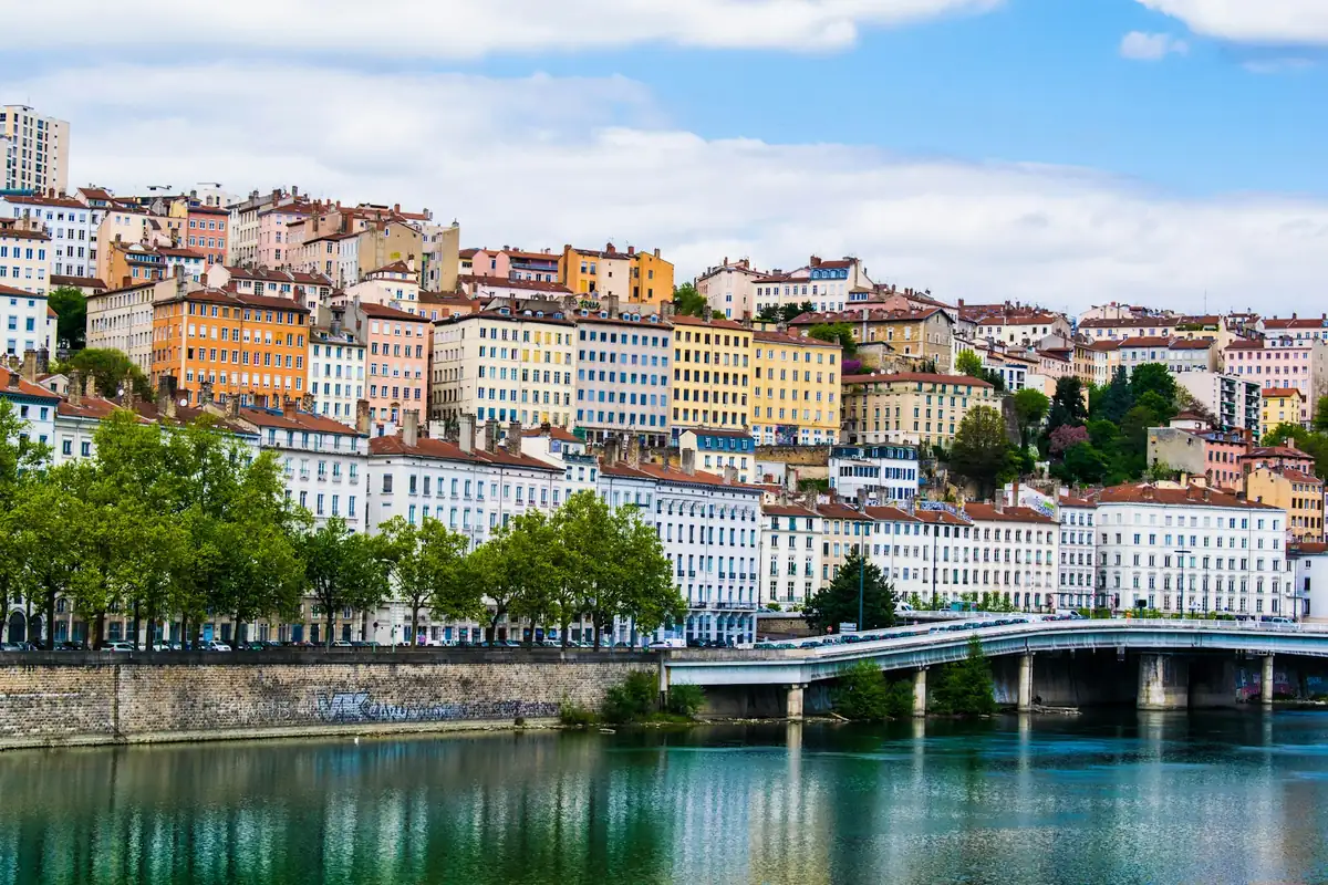 Façades colorées de Lyon au bord de l’eau sous un ciel bleu